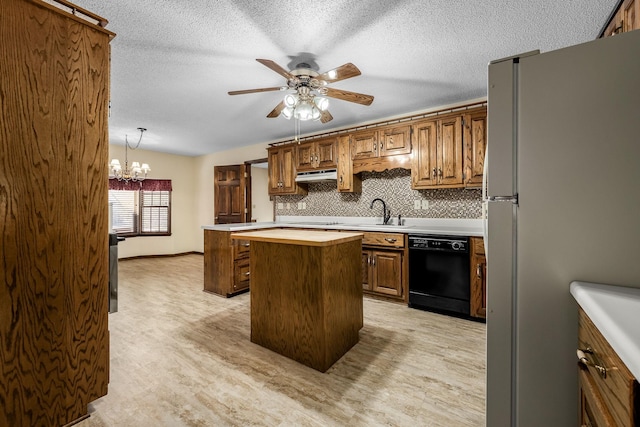 kitchen with pendant lighting, a center island, black dishwasher, tasteful backsplash, and fridge