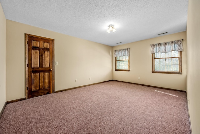 unfurnished room with carpet floors and a textured ceiling