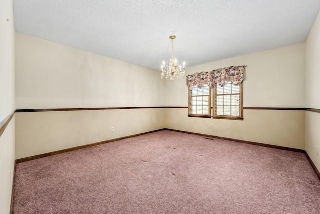 carpeted spare room with a notable chandelier