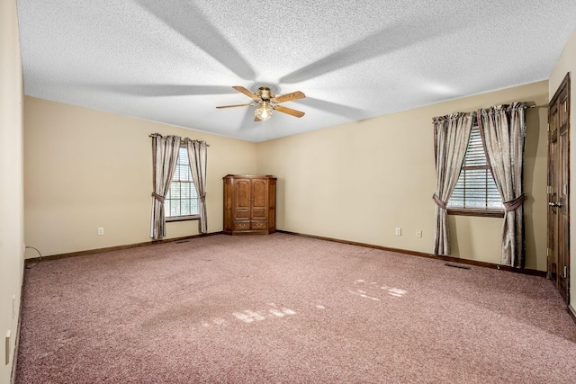 carpeted spare room featuring a textured ceiling and ceiling fan