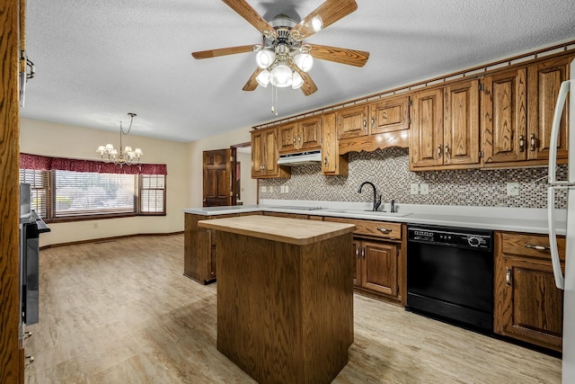 kitchen featuring black appliances, butcher block counters, hanging light fixtures, sink, and a kitchen island