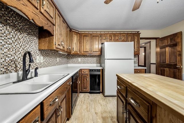 kitchen with dishwasher, sink, a textured ceiling, decorative backsplash, and white fridge