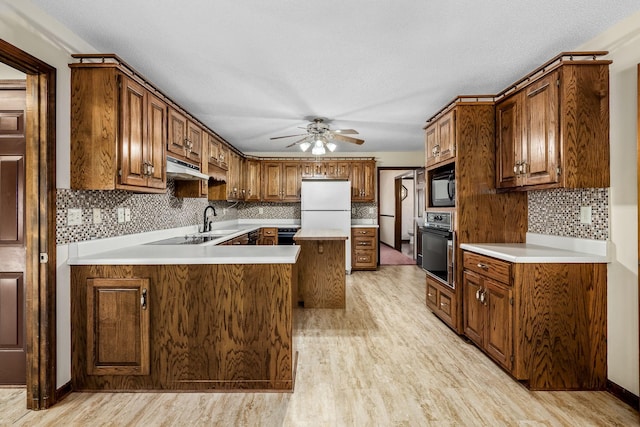 kitchen featuring a textured ceiling, black appliances, tasteful backsplash, ceiling fan, and light hardwood / wood-style flooring