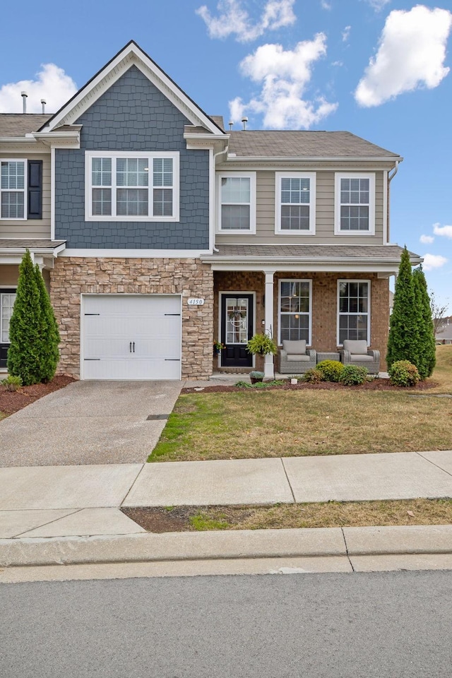 view of front of home featuring a garage, a front lawn, and a porch