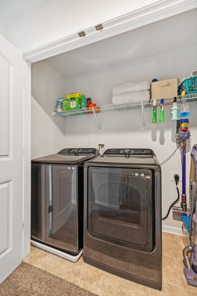 laundry room with washing machine and clothes dryer and light tile patterned floors