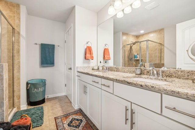 bathroom with a shower with shower door, tile patterned floors, and vanity