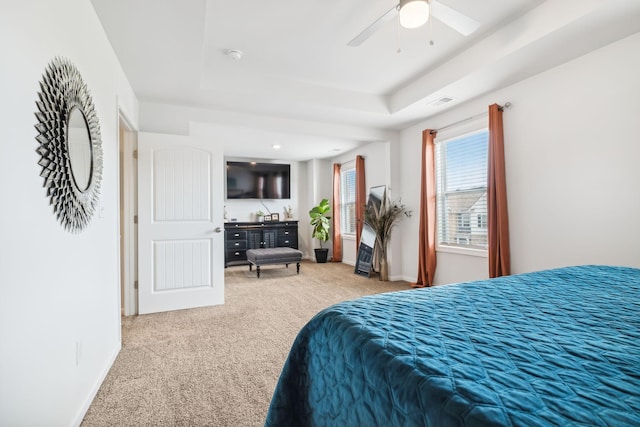 bedroom with ceiling fan, a raised ceiling, and carpet floors