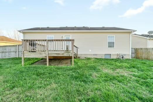 rear view of property with a wooden deck and a yard