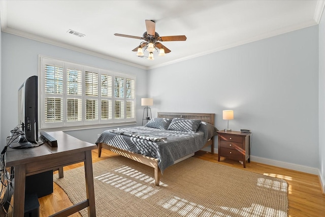 bedroom with ornamental molding, ceiling fan, and light hardwood / wood-style flooring