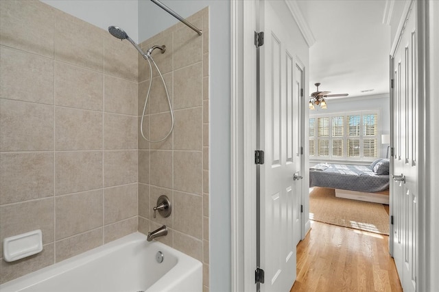 bathroom with tiled shower / bath combo, ceiling fan, and hardwood / wood-style flooring