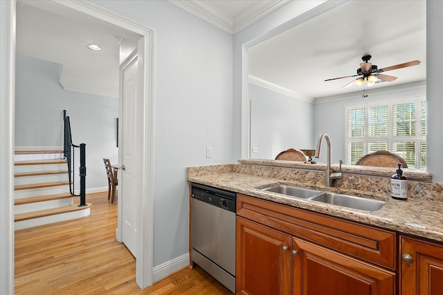 kitchen featuring light stone counters, sink, crown molding, and stainless steel dishwasher