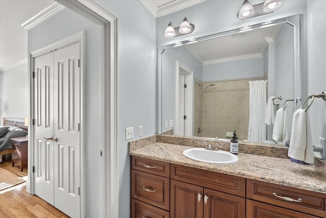 bathroom with crown molding, wood-type flooring, curtained shower, and vanity