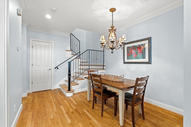 dining area with ornamental molding, light hardwood / wood-style floors, and a notable chandelier