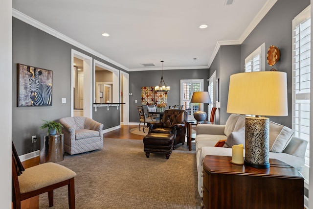 living room with ornamental molding, hardwood / wood-style floors, and a notable chandelier