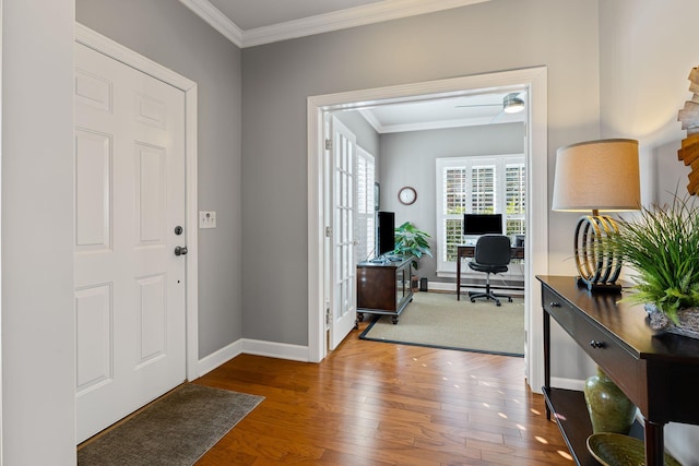 entryway with hardwood / wood-style flooring and crown molding