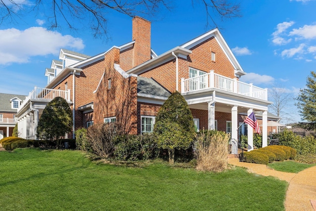 view of property exterior featuring a balcony and a lawn