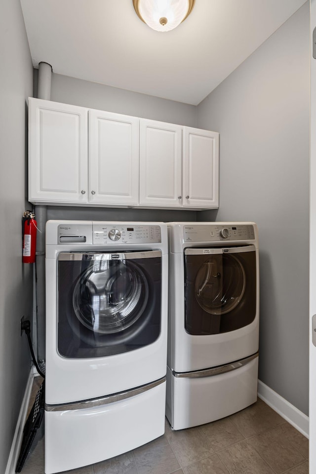 laundry area with cabinets and washer and clothes dryer