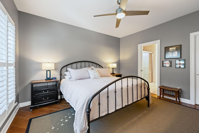 bedroom featuring connected bathroom, dark hardwood / wood-style floors, and ceiling fan