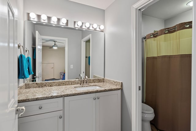 bathroom with vanity, a shower with shower curtain, ceiling fan, and toilet