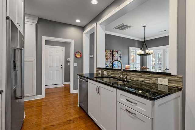 kitchen featuring stainless steel appliances, white cabinetry, sink, and dark stone counters