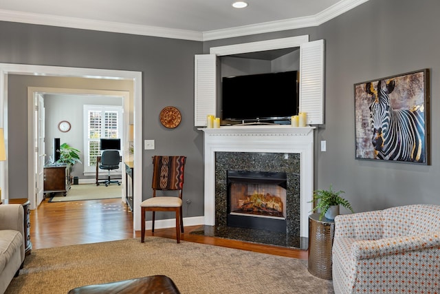 living room with hardwood / wood-style flooring, ornamental molding, and a high end fireplace