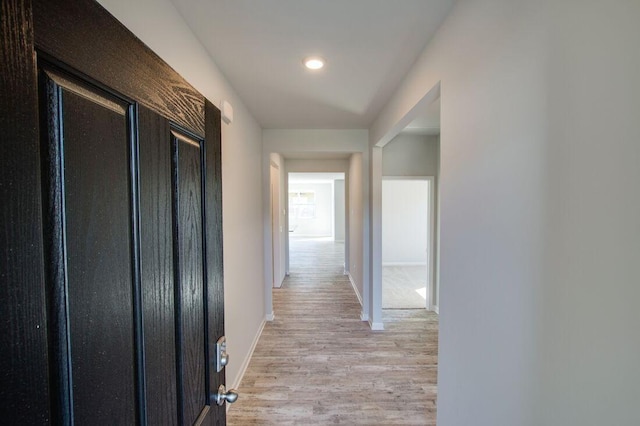 hallway with light hardwood / wood-style floors