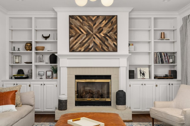 living room featuring dark wood-type flooring and a brick fireplace