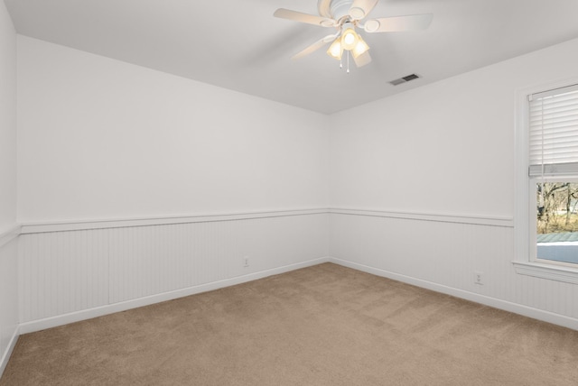 carpeted empty room with ceiling fan and a healthy amount of sunlight