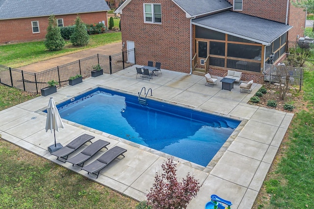 view of pool with a sunroom and a patio