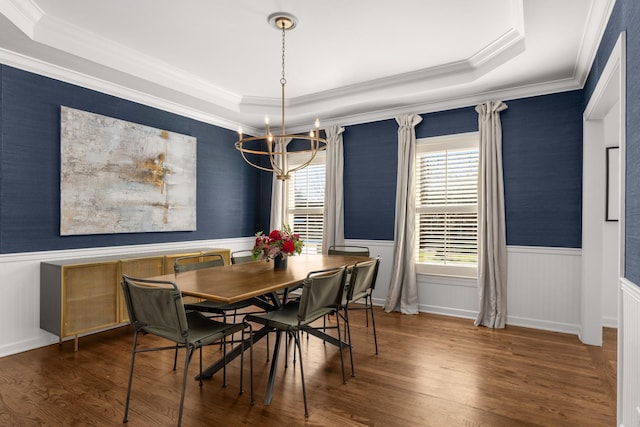 dining space with a chandelier, a raised ceiling, crown molding, and dark wood-type flooring