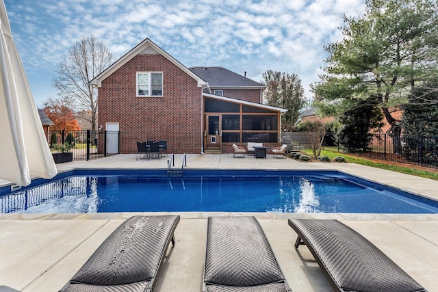 view of swimming pool with a sunroom and a patio