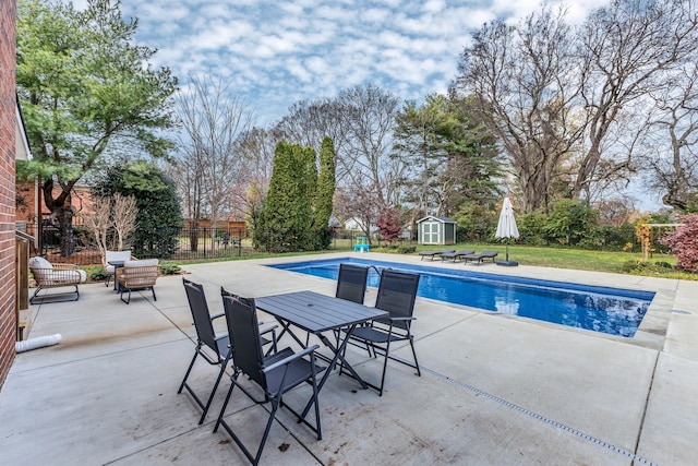 view of swimming pool with a storage shed and a patio