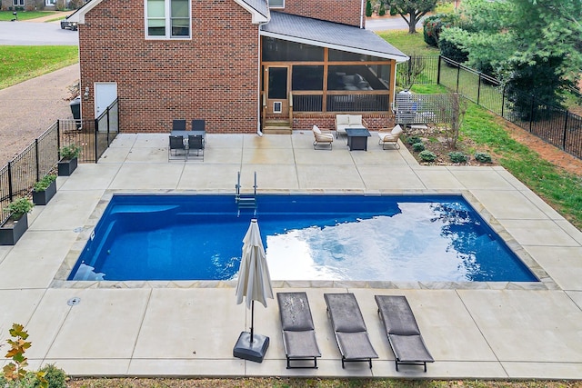 view of pool with a sunroom and a patio