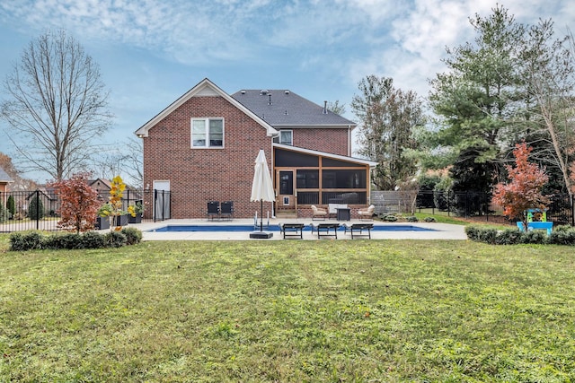 back of house featuring a patio area, a fenced in pool, a sunroom, and a lawn