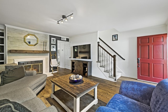 living room with ornamental molding, dark hardwood / wood-style floors, and rail lighting