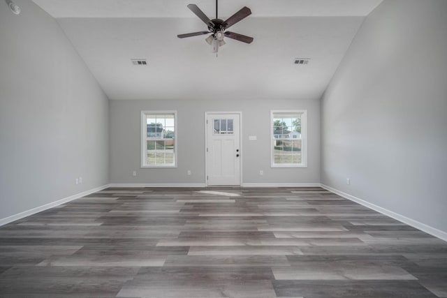 unfurnished living room featuring a healthy amount of sunlight, dark hardwood / wood-style floors, and lofted ceiling