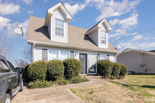 cape cod-style house with a front yard