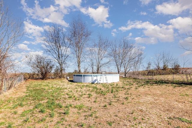 view of yard with a rural view and an empty pool