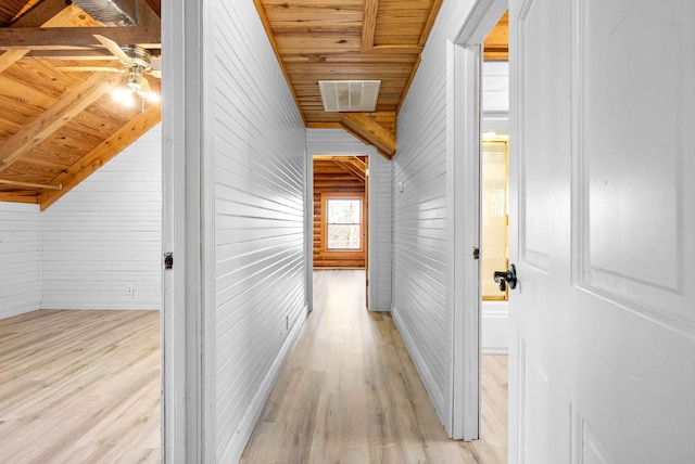 hall with wooden walls, light wood-type flooring, and wooden ceiling