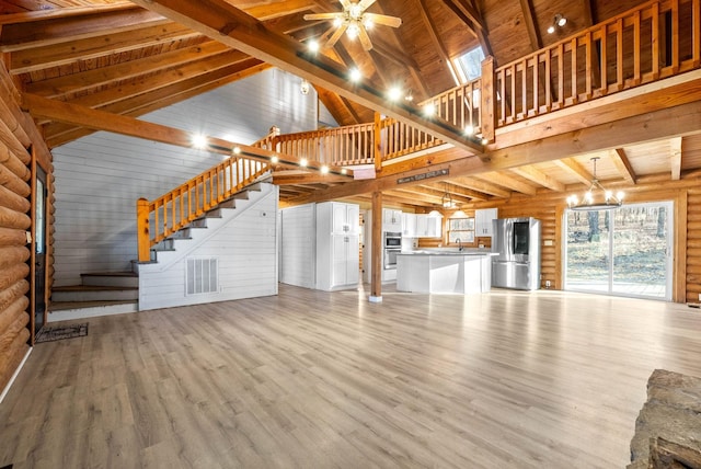 unfurnished living room featuring high vaulted ceiling, light hardwood / wood-style flooring, log walls, beam ceiling, and ceiling fan with notable chandelier