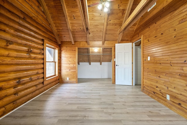 spare room featuring wood walls, vaulted ceiling with beams, rustic walls, wooden ceiling, and light wood-type flooring