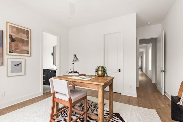 home office featuring light wood-type flooring and baseboards