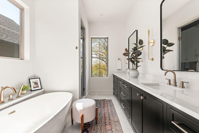 bathroom featuring a freestanding bath, double vanity, a stall shower, marble finish floor, and a sink