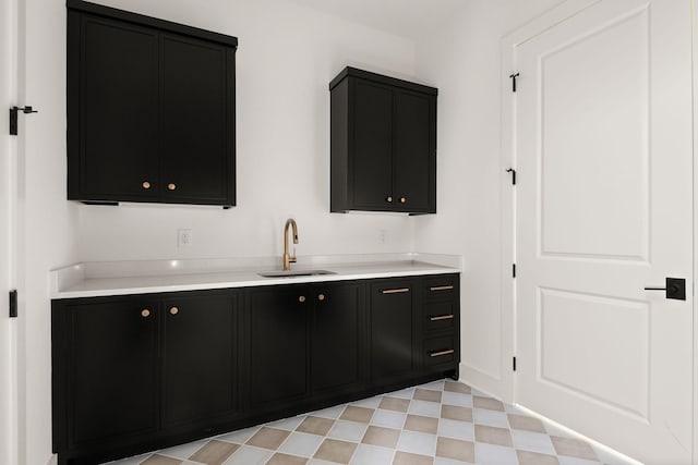 bar featuring a sink and light floors