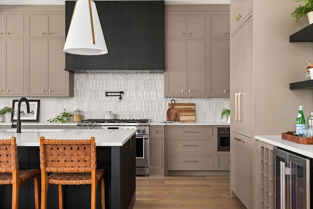 kitchen featuring decorative backsplash, stainless steel stove, wine cooler, light countertops, and custom range hood