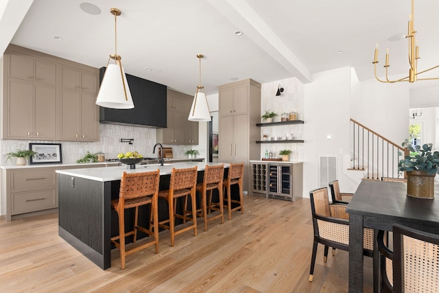 kitchen featuring visible vents, backsplash, light countertops, light wood-type flooring, and gray cabinets