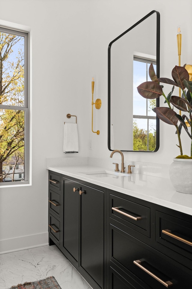 bathroom featuring baseboards, marble finish floor, and vanity