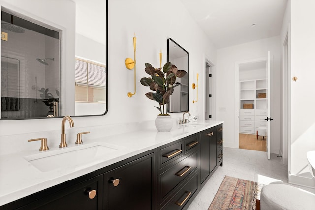 full bathroom featuring a sink, double vanity, and a tile shower