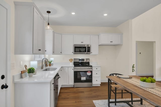 kitchen with white cabinetry, sink, decorative light fixtures, and appliances with stainless steel finishes