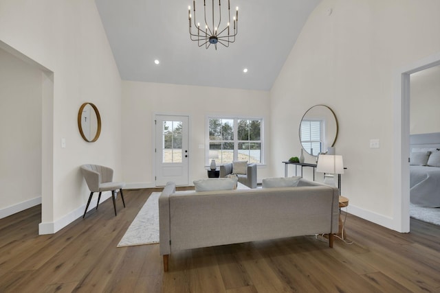 living room with dark wood-type flooring, high vaulted ceiling, and a notable chandelier